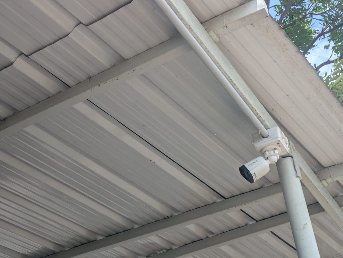 Outdoor CCTV camera installation under a commercial roof